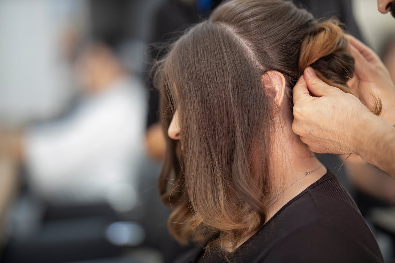 services-header Close-up of a hairstylist creating an elegant hairstyle for a woman in a salon.
